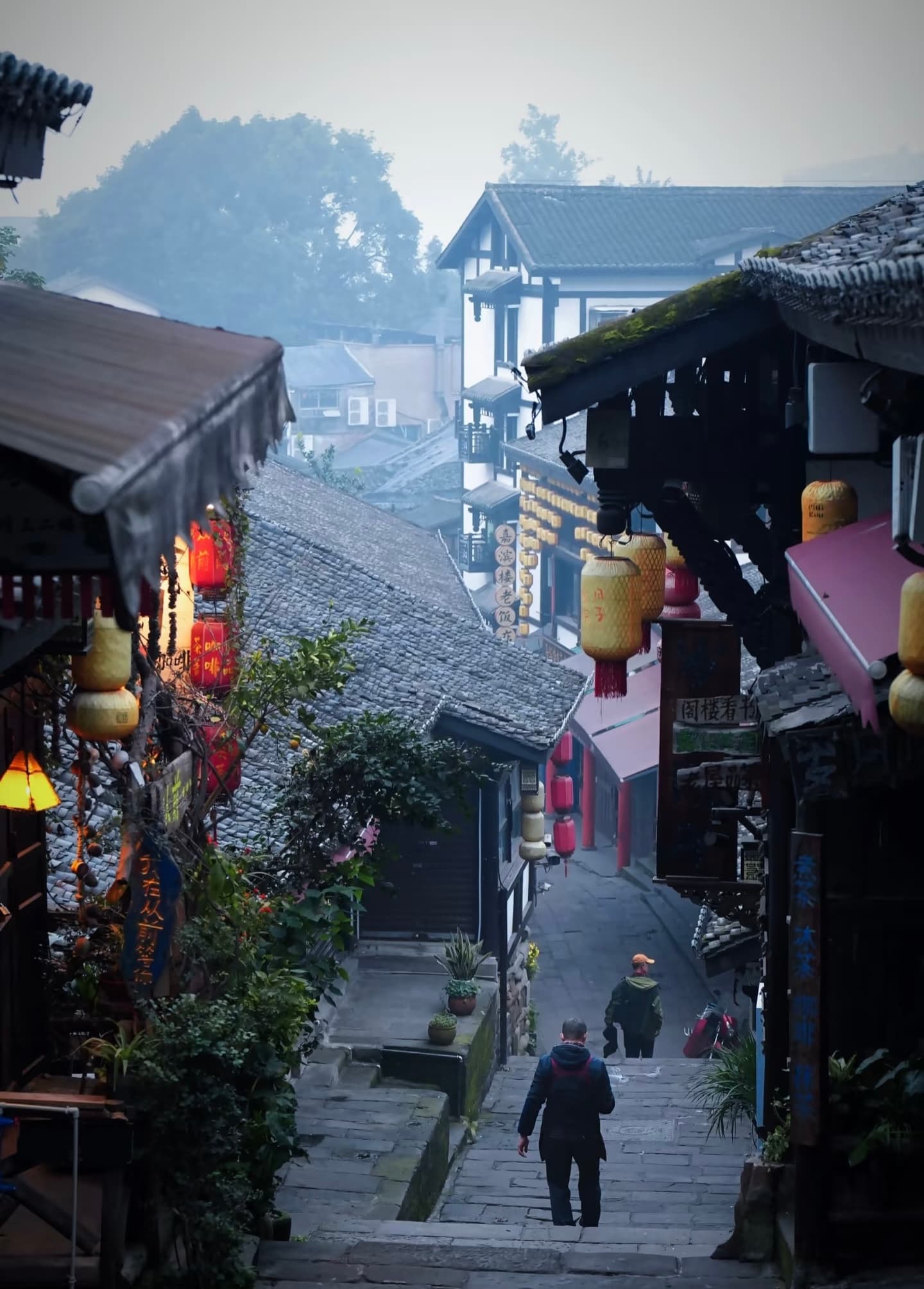A bustling, narrow stone street in Ciqikou Ancient Town with traditional buildings